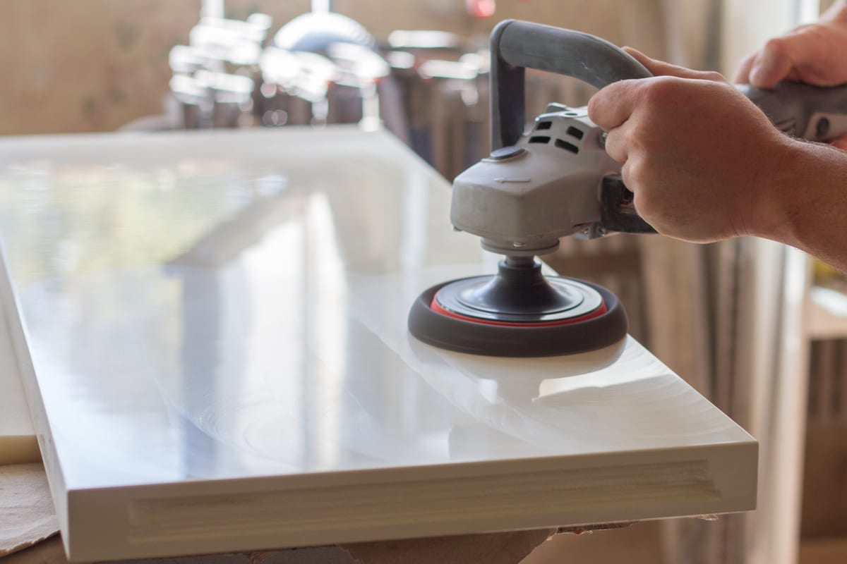 Refinisher machine-polishing a white countertop slab to a mirror gloss